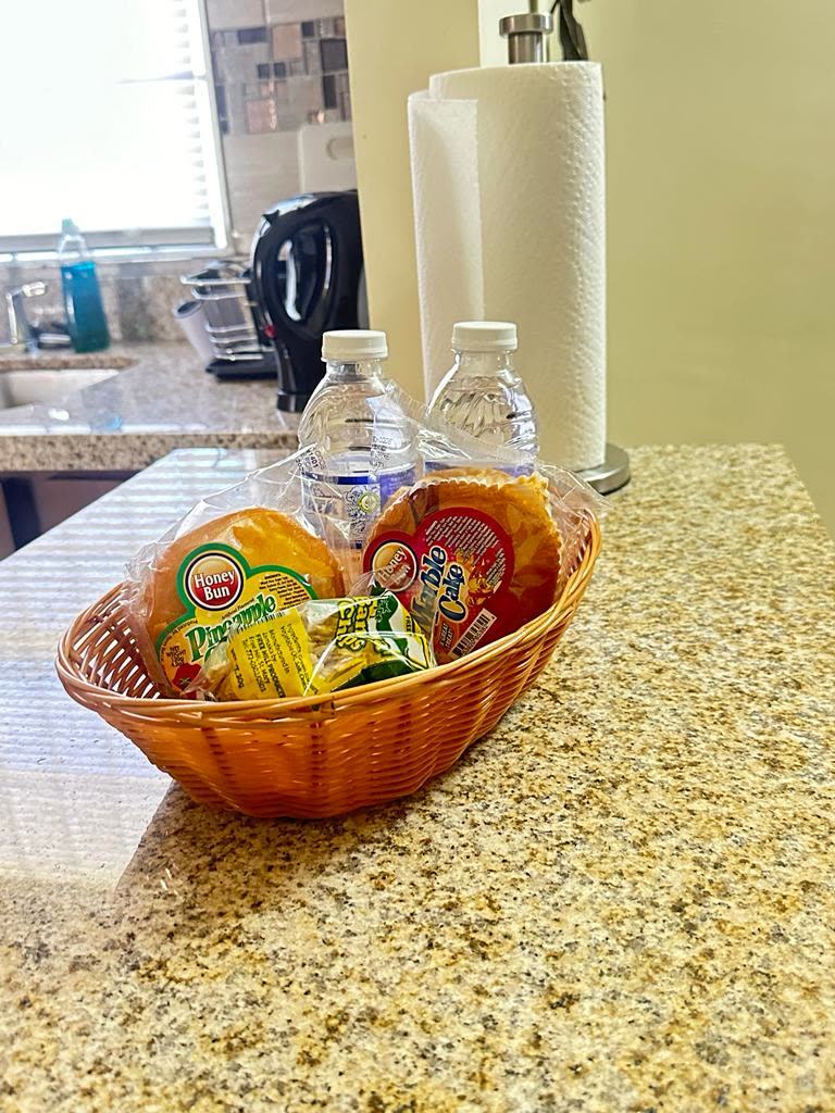 Basket of snacks and bottled water on the kitchen counter
