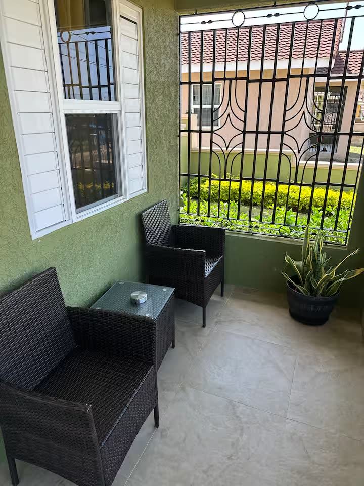 Covered patio with wicker chairs and a plant