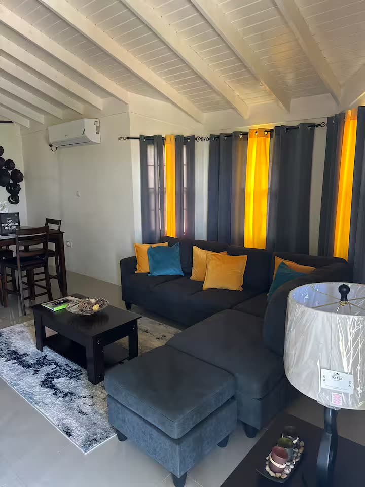 Living room with a gray sectional and a beamed ceiling